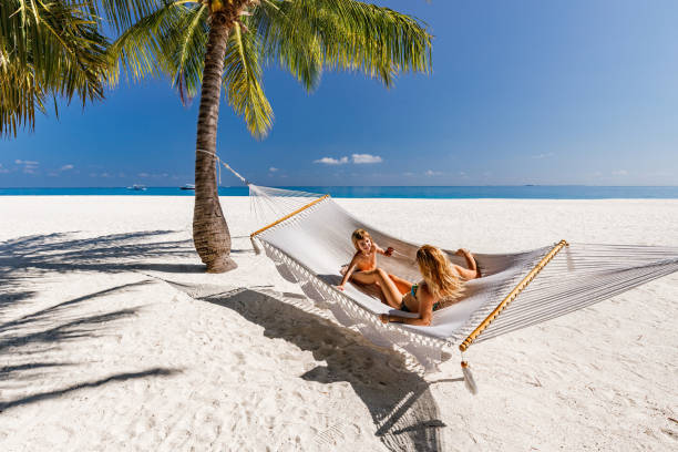 Happy boy and his single mother enjoying in hammock on the beach.