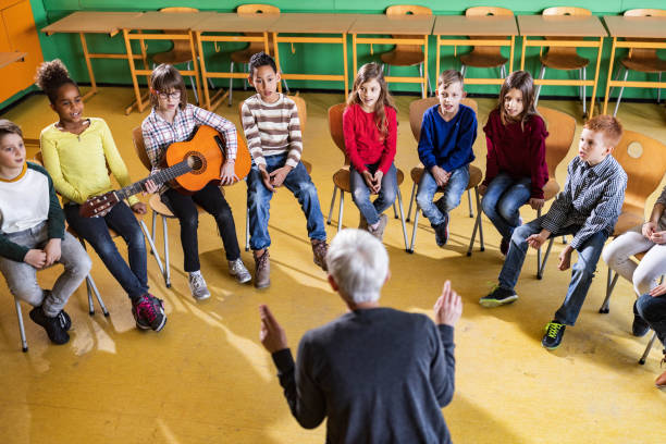 istock Large group of elementary students having a music class with their teacher. 1386826051