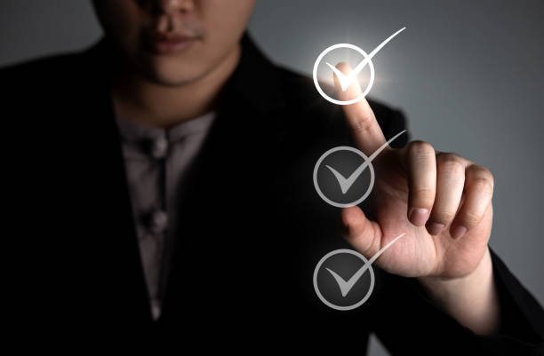 Checklist and make list. businessman writes a check mark by hand in a circle box. Project management, planning and maintaining scores of completed task ideas.