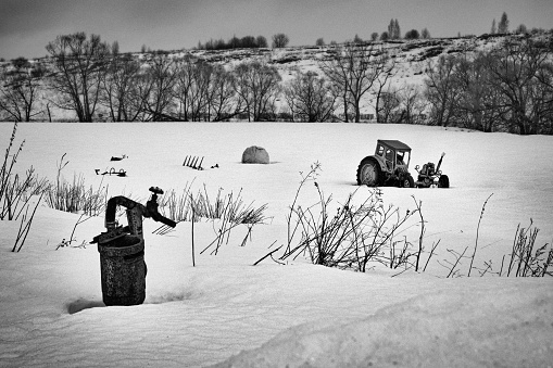 Strange broken tractor in a snowy field. Grain added.
