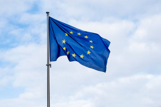 panoramiczny widok na powiewającą flagę ue lub flagę unii europejskiej na tle błękitnego nieba - european community government flag sign zdjęcia i obrazy z banku zdjęć