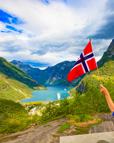 Norwegian flag with a Dramatic aerial view of lake town and fjords in background. Top of Fjords in Southern Norway - European Hiking and travel Concept