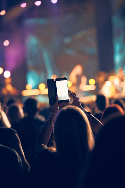 コンサートで現代のスマートフォンを持っている人。 - popular music concert mobile phone smart phone telephone ストックフォトと画像