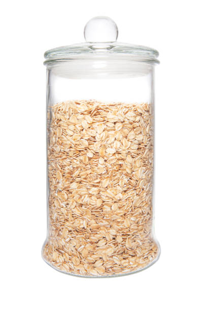 istock Raw pressed organic oats in glass jar on white background. 1386833040
