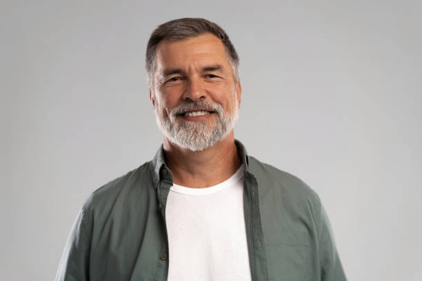 istock Portrait of smiling mature man standing on white background 1386833407