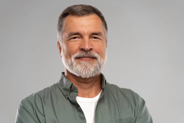 istock Portrait of smiling mature man standing on white background 1386833421