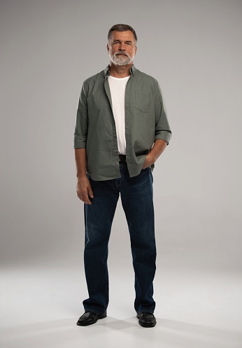 Full length shot of smiling mature man standing on white background.