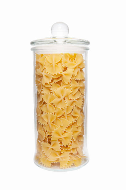 istock Uncooked pasta in glass jar on white background. 1386833572
