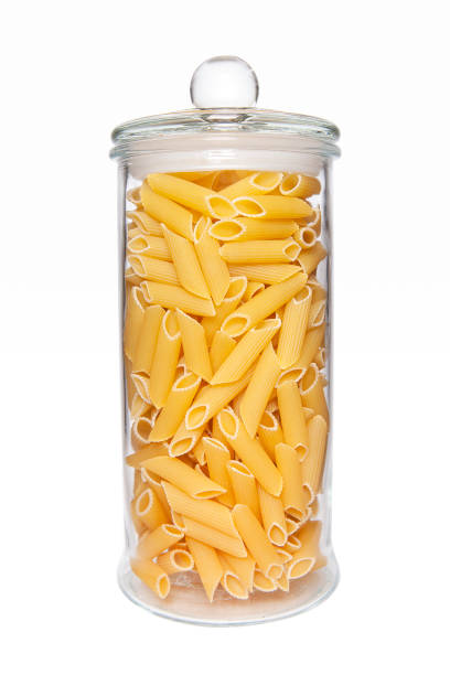 istock Uncooked pasta in glass jar on white background. 1386833819