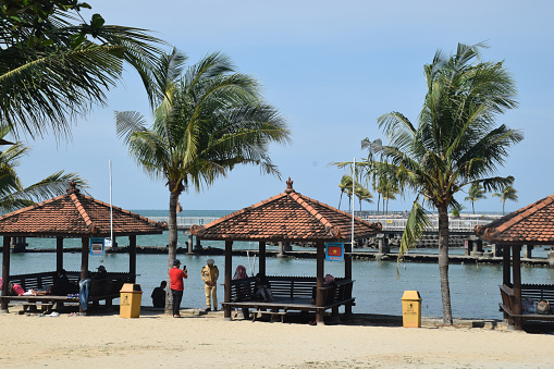 A hut with coconut trees near the beach at the Lamongan Marine Tourism complex in Paciran, East Java, Indonesia on December 26, 2021