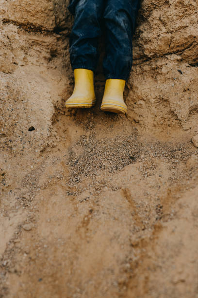 istock Child With Yyellow Rubber Boots Playing On Sand 1386834755