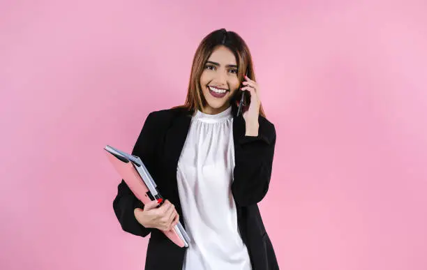 Photo of young hispanic business woman smiling at camera on pink background in Mexico Latin America