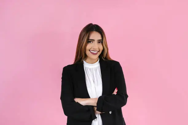 Photo of young hispanic business woman smiling at camera on pink background in Mexico Latin America