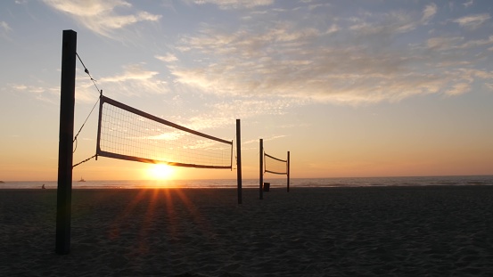 Silueta de red de voleibol en cancha deportiva de playa al atardecer, costa de California, EE. UU. photo