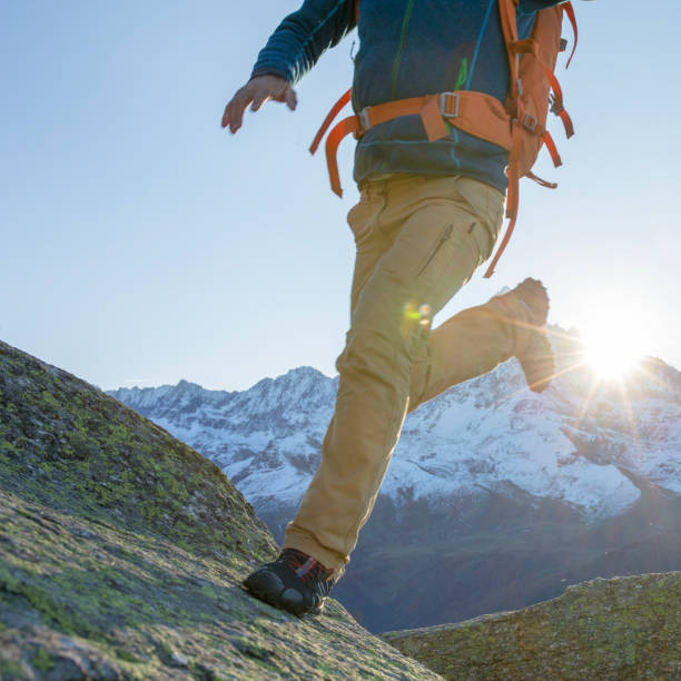 istock Athletic hiker jumps between rocks at sunset 1386842031