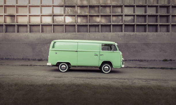 Kyiv, Ukraine - June 06 2015: Green classic Volkswagen Transporter bus parked in front of concrete wall, side profile view