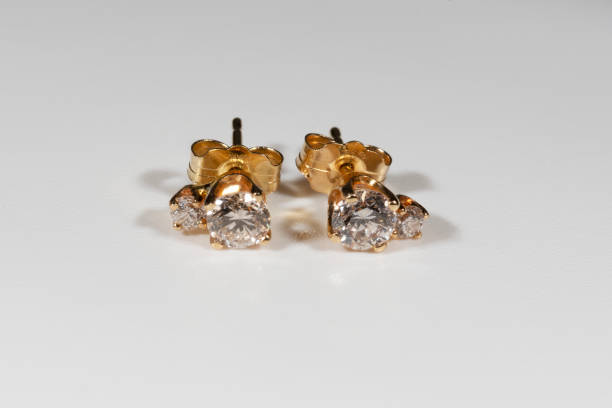 istock Yellow gold earrings with natural round diamonds on a white background 1386843621