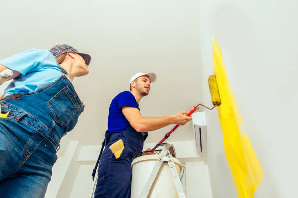 istock Man standing on scale painting walls with yellow color 1386850749