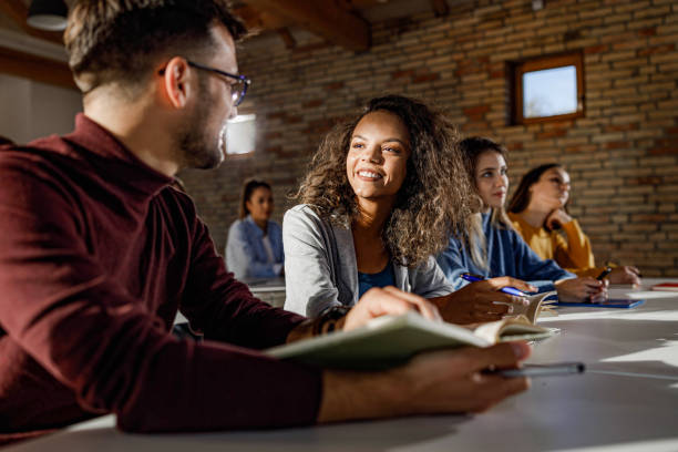 istock Happy university students talking on a class in the classroom. 1386850907