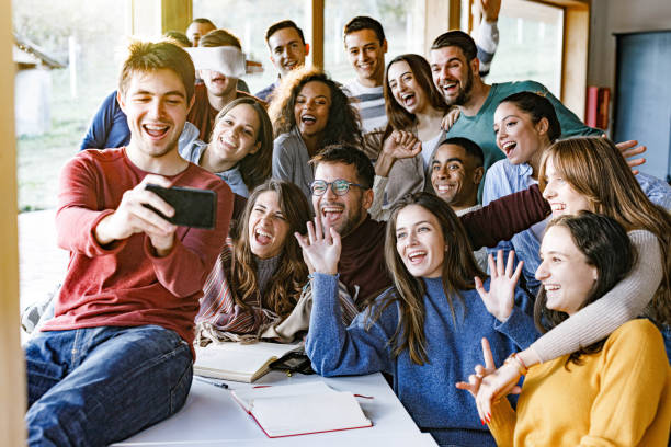 istock Happy students taking a selfie with cell phone in the classroom. 1386851501