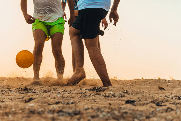 istock Group of people enjoying a soccer game on beach 1386852384