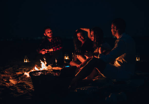 istock Happy friends having fun around bonfire 1386852509