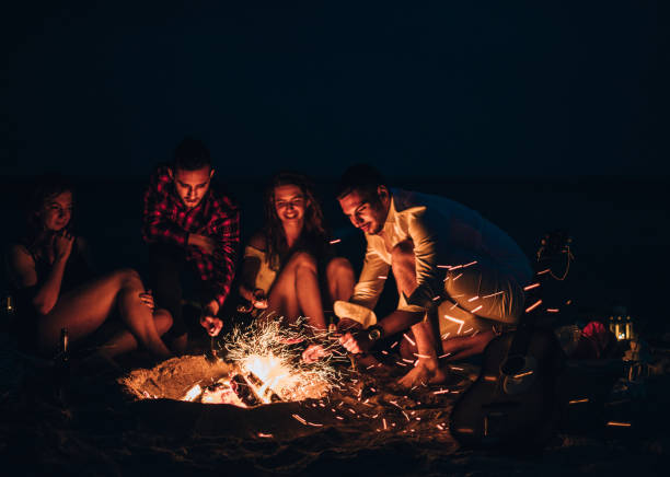 istock Happy friends having fun around bonfire 1386852515