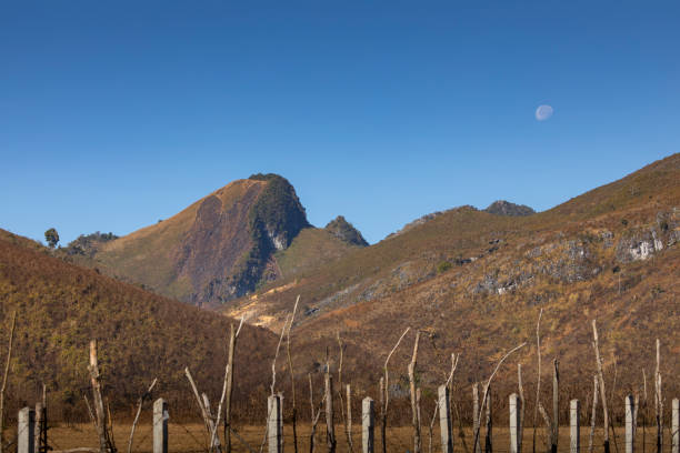 Dry landscape of mountains and moon in Vientian Province, Laos A strange landscape of mountains and vegetation dried out by the lack of rain, in the daytime, with the moon in the sky, in Vientian Province, Laos vientian stock pictures, royalty-free photos & images