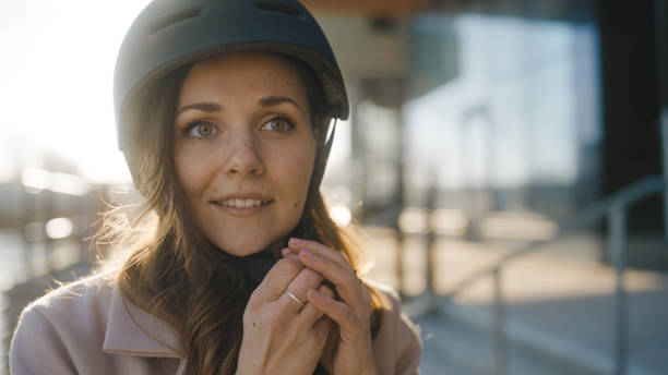 istock Woman putting her helmet on before biking home 1386855782