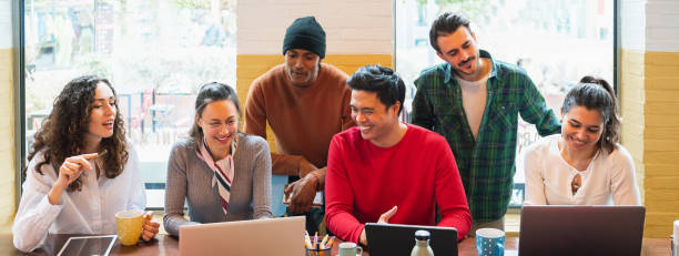 istock Horizontal banner or header multiracial group of young people working around computers with positive, smiling faces. 1386856168