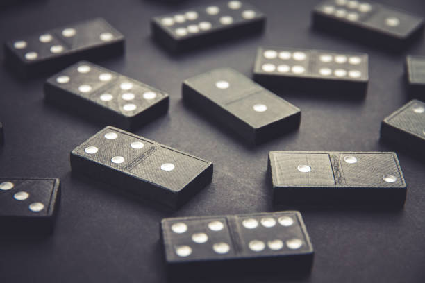 istock Black dominoes on dark table background 1386856179