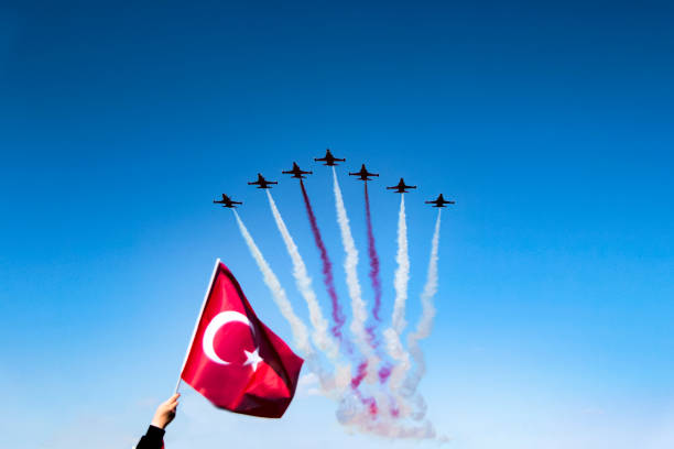 Turkish jets performing in the sky. Antalya, Turkey - April 23, 2017: Turkish Jets demonstrating in the skies of Antalya to celebrate the Republic Day and a person who has raised the Turkish Flag to the air. aerobatics photos stock pictures, royalty-free photos & images