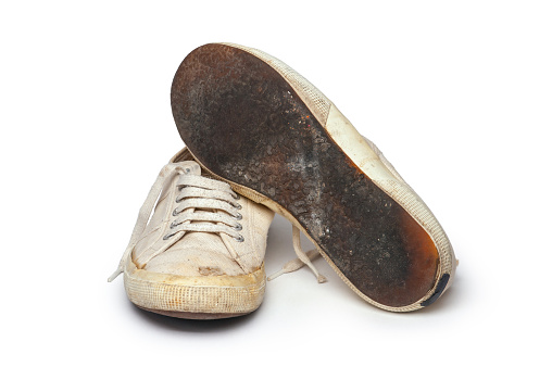 Close-up of old and dirty canvas tennis shoes, isolated on white.