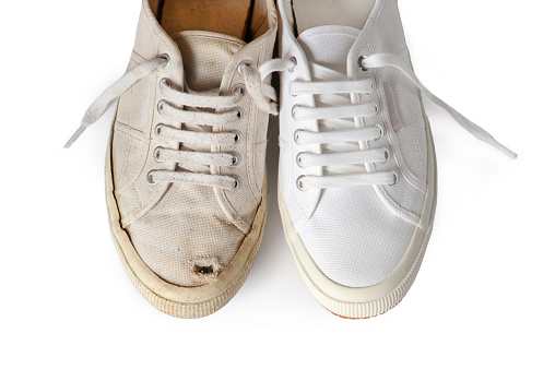 Close-up of an old and new canvas tennis shoe, isolated on white.