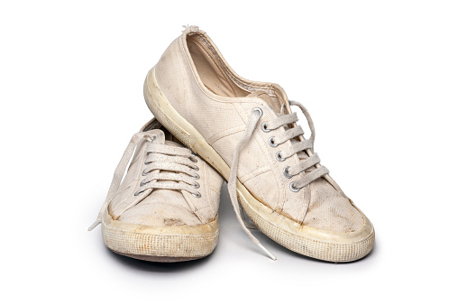Close-up of old and dirty canvas tennis shoes, isolated on white.