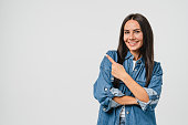 Happy smiling caucasian young woman with toothy white smile looking at camera pointing showing copy space free space isolated in white background