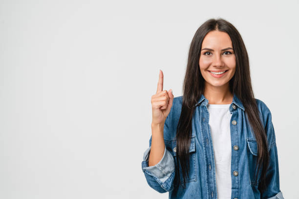 erfolgreiches selbstbewusstes junges kaukasisches europäisches frauenmädchen, das auf den kopierraum nach oben zeigt, eine idee hat, gedankenlos in weißem hintergrund denkt - surprise ideas business person pointing stock-fotos und bilder