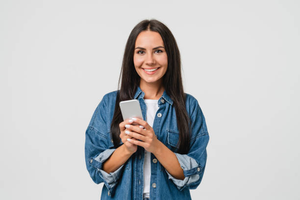 eラーニング、電子商取引、電子バンキングオンライン、モバイルアプリケーション、白い背景で孤立したカジノで賭けをするためにスマートフォンの携帯電話を使用して笑顔の白人の若い女 - white women ストックフォトと画像