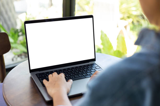 istock mock up empty screen notebook, businesswoman working on his laptop computer with blank space screen for advertising text on wood desk in Cafe 1386863962