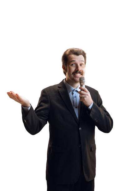 istock Emotive young man, professional sport commentator, journalist with microphone broadcasting football match isolated over white background. Sport, news concept 1386864102