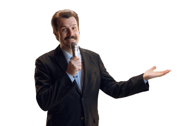 istock Emotive young man, professional sport commentator, journalist with microphone broadcasting football match isolated over white background. Sport, news concept 1386864109