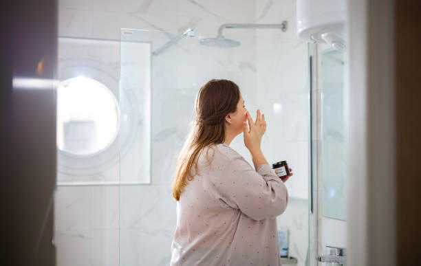 istock Plus Size Woman Applying Face Cream in the Bathroom 1386864168