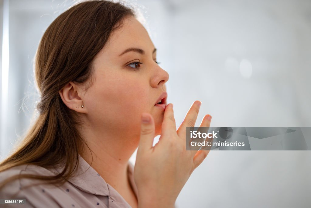 Portrait of a Woman Touching Her Lip Portrait of a woman looking forward and touching her lip. Human Lips Stock Photo
