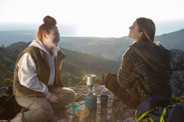 istock Happy female backpackers resting on top of mountain 1386864404