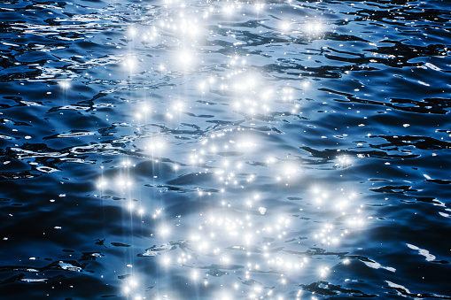 Ripples on lake water. Idyllic dreamy sunlight glitter.