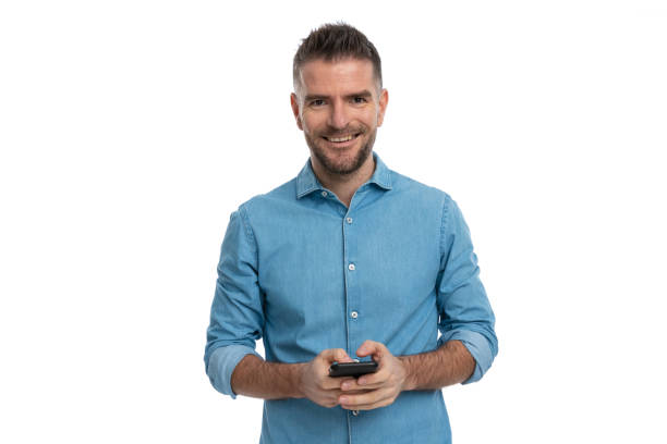 istock happy unshaved man in denim shirt smiling while holding mobile 1386865344