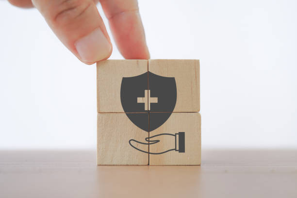 security with hospital or clinic symbol inside over hand icon on wooden cube blocks for health insurance concept stock photo