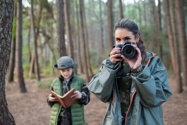 istock Beautiful woman with camera in forest 1386866355