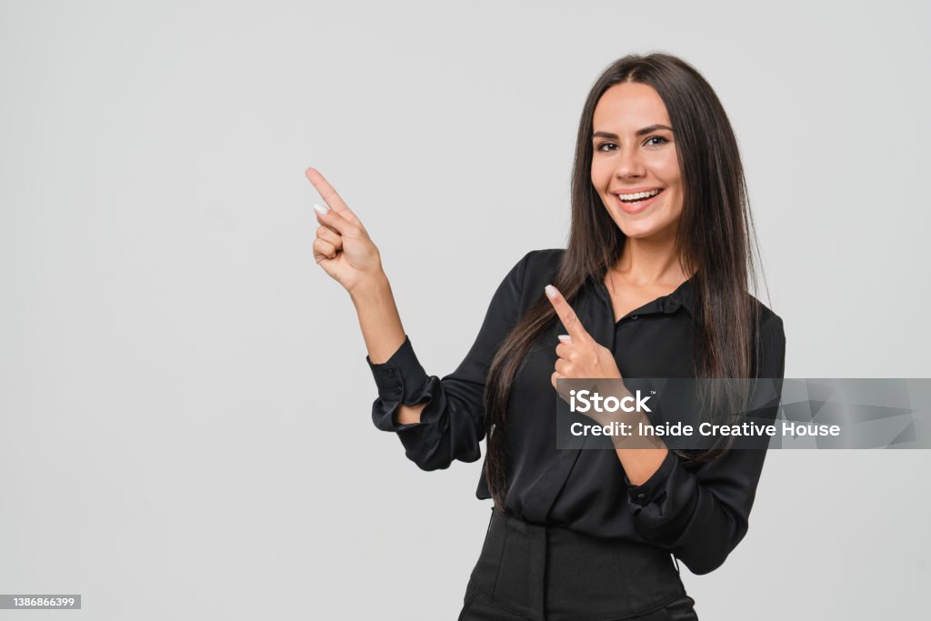 Confident caucasian young businesswoman freelancer CEO boss manager bank employee in formal wear looking at camera pointing at free copy space isolated in white background Pointing Stock Photo