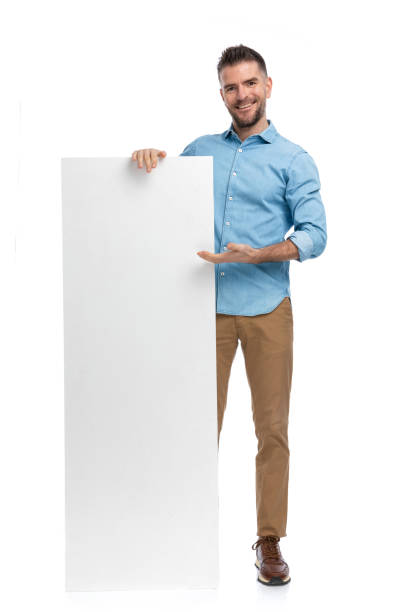 istock proud guy in denim shirt holding and presenting empty board 1386866500